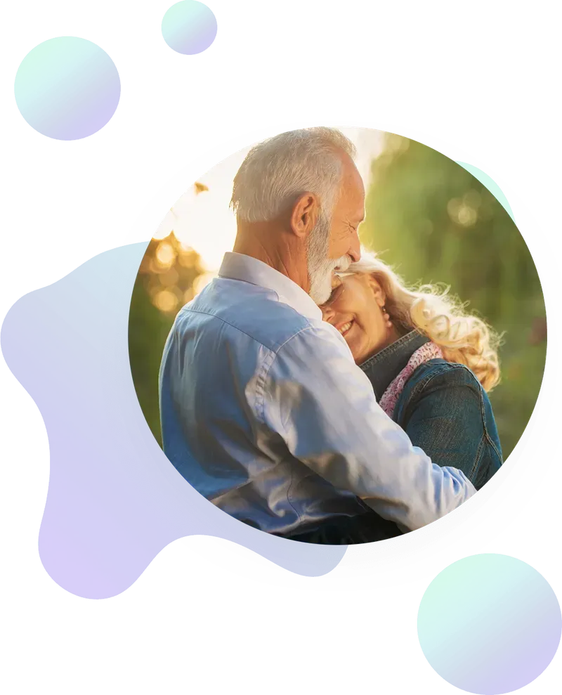An older couple embraces outdoors, smiling and looking happy; the image is framed by abstract blue and green shapes.