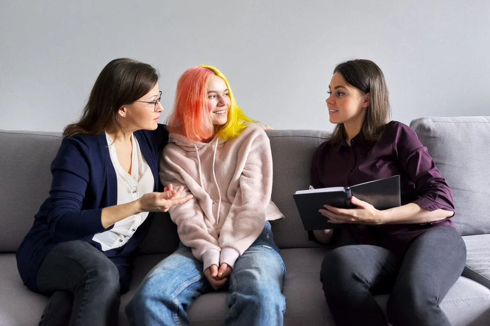 Mother and young adult daughter in meeting with a medical professional.