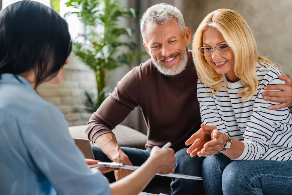 Middle aged man and wife at a medical consultation with a healthcare professional.