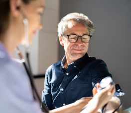 Doctor Measuring Blood Pressure Of Male Patient