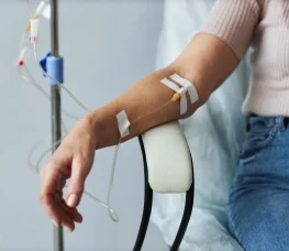 Close up of a woman’s arm connected to an IV.